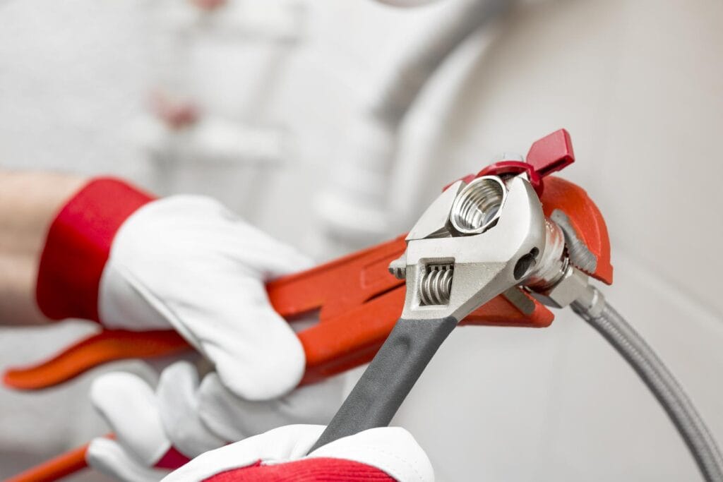 Plumber holding pipe wrenches for an emergency repair in Miami