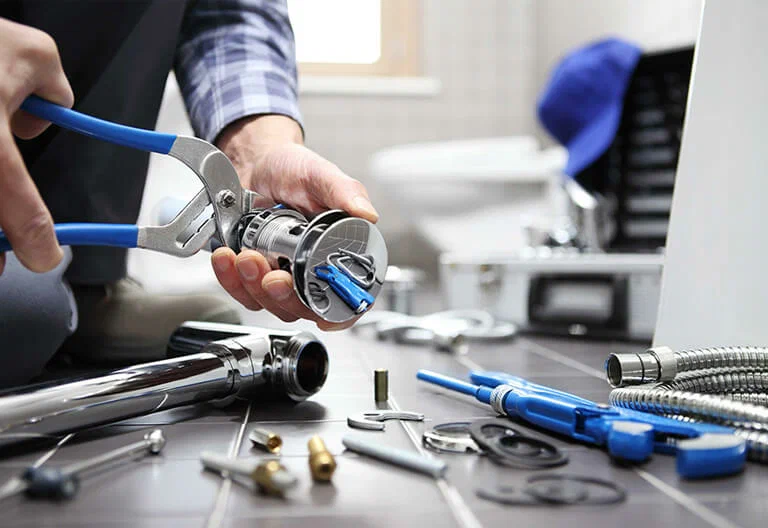 Technician repairing a plumbing fixture with professional tools in Miami