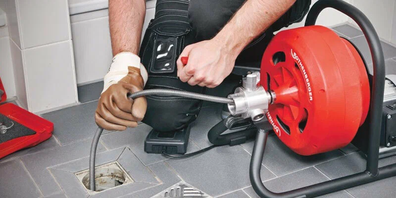 Plumber using a drain-cleaning machine in Miami